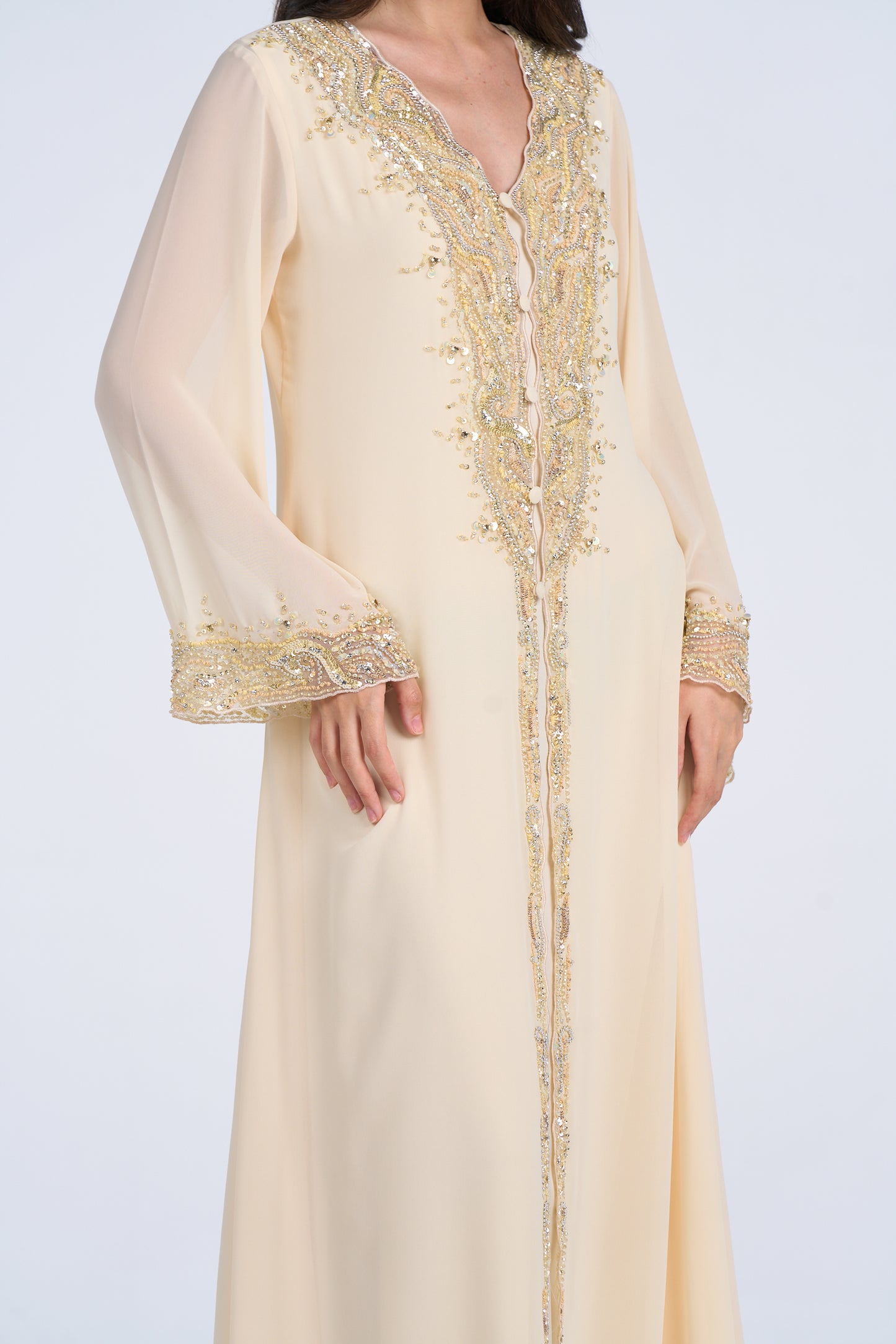 Beige dress with gold embroidery on a plain background