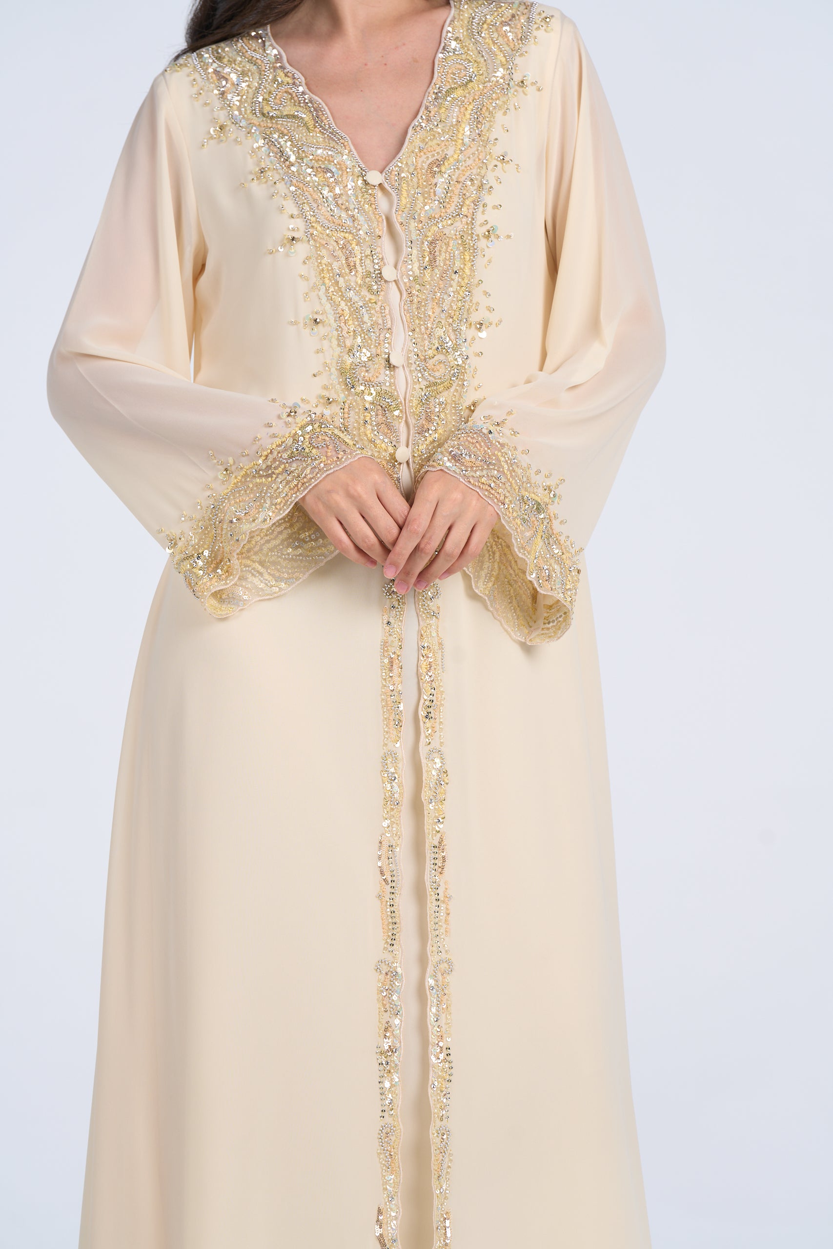 Beige dress with gold embroidery on a plain background